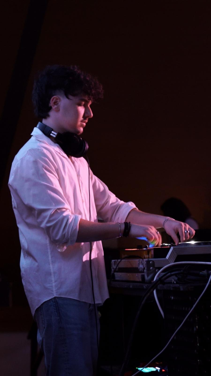 DJ KIPI בחולצה לבנה מכופתרת מאחורי הדק